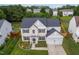 Aerial view of a two-story home with well-maintained landscaping, a two-car garage, and a charming front porch at 7612 Vista Del Rey Ln, Raleigh, NC 27613