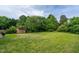 A well-maintained backyard with green grass, mature trees and a storage shed at 7612 Vista Del Rey Ln, Raleigh, NC 27613