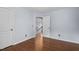 Bedroom features hardwood floors, a doorway to the hallway and two white doors at 7612 Vista Del Rey Ln, Raleigh, NC 27613