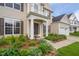 Inviting front porch with elegant white columns, lush landscaping, and a well-maintained walkway to the front door at 7612 Vista Del Rey Ln, Raleigh, NC 27613