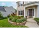 Charming front yard landscaping with a stone border, featuring vibrant green plants and a walkway to the front door at 7612 Vista Del Rey Ln, Raleigh, NC 27613