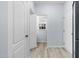 Hallway with hardwood-style floors leading to closet and open doorway with natural light at 7612 Vista Del Rey Ln, Raleigh, NC 27613