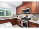 Gourmet kitchen with granite countertops, stainless steel appliances, and wood cabinets at 7612 Vista Del Rey Ln, Raleigh, NC 27613