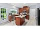 Well-lit kitchen with granite counters, stainless appliances, a center island, and access to the backyard at 7612 Vista Del Rey Ln, Raleigh, NC 27613