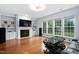 Spacious living room with a fireplace, built-in shelves, and ample natural light from large windows at 7612 Vista Del Rey Ln, Raleigh, NC 27613