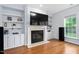 Living room with fireplace and built-in shelving and large windows at 7612 Vista Del Rey Ln, Raleigh, NC 27613