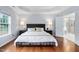 Bedroom with tray ceiling, wood floors, and ensuite bathroom visible through the doorway at 7612 Vista Del Rey Ln, Raleigh, NC 27613