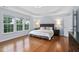 Large bedroom with tray ceiling, hardwood floors, and big windows letting in natural light at 7612 Vista Del Rey Ln, Raleigh, NC 27613