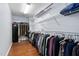 Walk-in closet with built-in shelving, hanging racks and wood floor at 7612 Vista Del Rey Ln, Raleigh, NC 27613