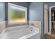 Bright bathroom features a modern tub with tiled backsplash and a frosted window at 784 Cypress Rd, Cameron, NC 28326