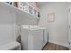 Well-lit laundry room features modern white washer and dryer and storage shelves at 784 Cypress Rd, Cameron, NC 28326
