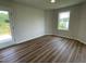 Cozy bedroom with wood-look flooring, access to a porch and a bright window at 81 Coharie Dr, Lillington, NC 27546