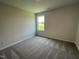 Comfortable bedroom features neutral walls and carpet along with a well-lit window at 81 Coharie Dr, Lillington, NC 27546