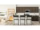 Modern kitchen with dark cabinets, stainless steel appliances, white backsplash, and a center island with seating for three at 84 Blossom Field Way, Angier, NC 27501