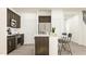 Bright kitchen with dark cabinets, stainless steel appliances, a white backsplash, and an island with seating space at 84 Blossom Field Way, Angier, NC 27501