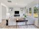 Bright living room with a gray sofa, modern furniture, and large windows overlooking the outdoor landscape at 841 Ottawa Dr, Garner, NC 27529