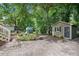 Charming backyard with a brick patio, a cozy shed, and lush greenery at 847 E Maple Ln, Fuquay Varina, NC 27526