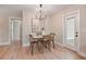 Inviting dining area features wood table, modern chandelier, and light hardwood floors at 847 E Maple Ln, Fuquay Varina, NC 27526