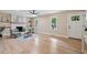 Bright living room with hardwood floors, ceiling fan, fireplace, built-in shelves, and natural light from two large windows at 847 E Maple Ln, Fuquay Varina, NC 27526