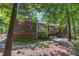Home's backyard with screened porch, wooden deck, mature trees, and natural landscaping with a stone pathway at 850 N Langdon, Pittsboro, NC 27312