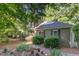 Charming home featuring solar panels, black shutters, and a beautifully landscaped front yard with lush greenery at 850 N Langdon, Pittsboro, NC 27312