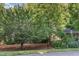 View of a home surrounded by mature trees and lush landscaping in a serene, wooded setting at 850 N Langdon, Pittsboro, NC 27312