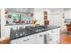 Gourmet kitchen island features a gas cooktop and sleek black countertops with white cabinetry at 850 N Langdon, Pittsboro, NC 27312