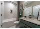 Stylish bathroom featuring a tub with shower, neutral tile, and green vanity with a white countertop at 91 Ivy Ridge Rd, Chapel Hill, NC 27516