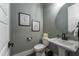Stylish powder room featuring a pedestal sink, round mirror, and modern fixtures at 91 Ivy Ridge Rd, Chapel Hill, NC 27516