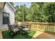 Outdoor dining area on a wooden deck surrounded by lush greenery and a railing for safety at 91 Ivy Ridge Rd, Chapel Hill, NC 27516