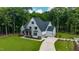 Aerial view of a two-story home with a sprawling driveway, attached garage, and landscaped front yard at 91 Ivy Ridge Rd, Chapel Hill, NC 27516