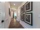 Well-lit hallway with wood flooring, decorative artwork, and open doorway to dining area at 91 Ivy Ridge Rd, Chapel Hill, NC 27516