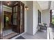 Inviting front porch with a chair, open wooden door, and neutral brick exterior at 91 Ivy Ridge Rd, Chapel Hill, NC 27516