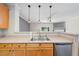 Kitchen featuring stainless steel dishwasher and sink with views into the living area at 1003 Crimson Dr, Durham, NC 27713