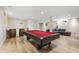 Finished basement with a red felt pool table, rustic barrel bar, and neutral color palette at 1005 Temple St, Raleigh, NC 27609