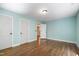 Bedroom with aqua walls, two doors, and laminated wood flooring at 1005 Temple St, Raleigh, NC 27609