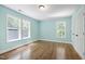 Bright bedroom with light aqua walls, wood floors, and natural light from windows at 1005 Temple St, Raleigh, NC 27609