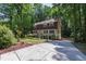 Two story home with a long driveway and mature trees and shrubs at 1005 Temple St, Raleigh, NC 27609