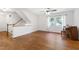 Bright living room with hardwood floors, staircase, and a decorative piano near the window at 1005 Temple St, Raleigh, NC 27609