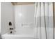 Clean bathtub and shower combination with a white curtain and bronze fixtures at 1005 Temple St, Raleigh, NC 27609