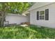 Back of house featuring white siding, a window, and an overgrown yard at 102 S College Ave, Kenly, NC 27542