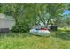 Backyard view showing a large propane tank and mature trees at 102 S College Ave, Kenly, NC 27542