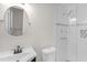 Bathroom featuring a modern vanity, toilet, and walk-in shower with glass doors and tile surround at 102 S College Ave, Kenly, NC 27542