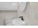 Bright bathroom featuring a white pedestal sink, toilet and cabinet at 102 S College Ave, Kenly, NC 27542