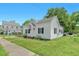 Quaint white home with black shutters, covered parking, and mature landscaping at 102 S College Ave, Kenly, NC 27542