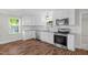 Modern kitchen boasts stainless steel appliances, granite counters, and wood floors at 102 S College Ave, Kenly, NC 27542