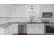 Renovated kitchen features white cabinets, granite countertops, and stainless appliances at 102 S College Ave, Kenly, NC 27542