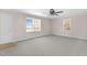 Large living room with carpet flooring, neutral walls, and multiple windows at 102 S College Ave, Kenly, NC 27542