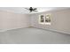 Open living room with carpeting features a bright window and neutral walls at 102 S College Ave, Kenly, NC 27542