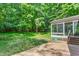 View of the backyard with lush trees and screened-in porch at 102 Winged Foot Ct, Mebane, NC 27302